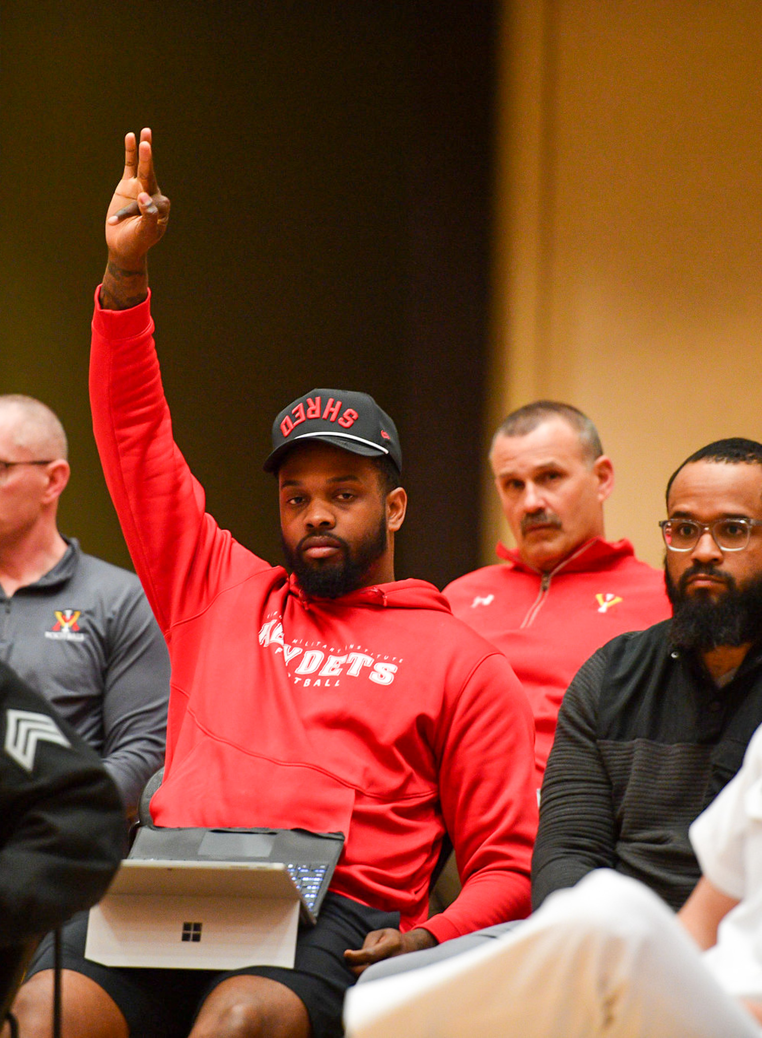 Participant in red hoodie engaging in dialogue session