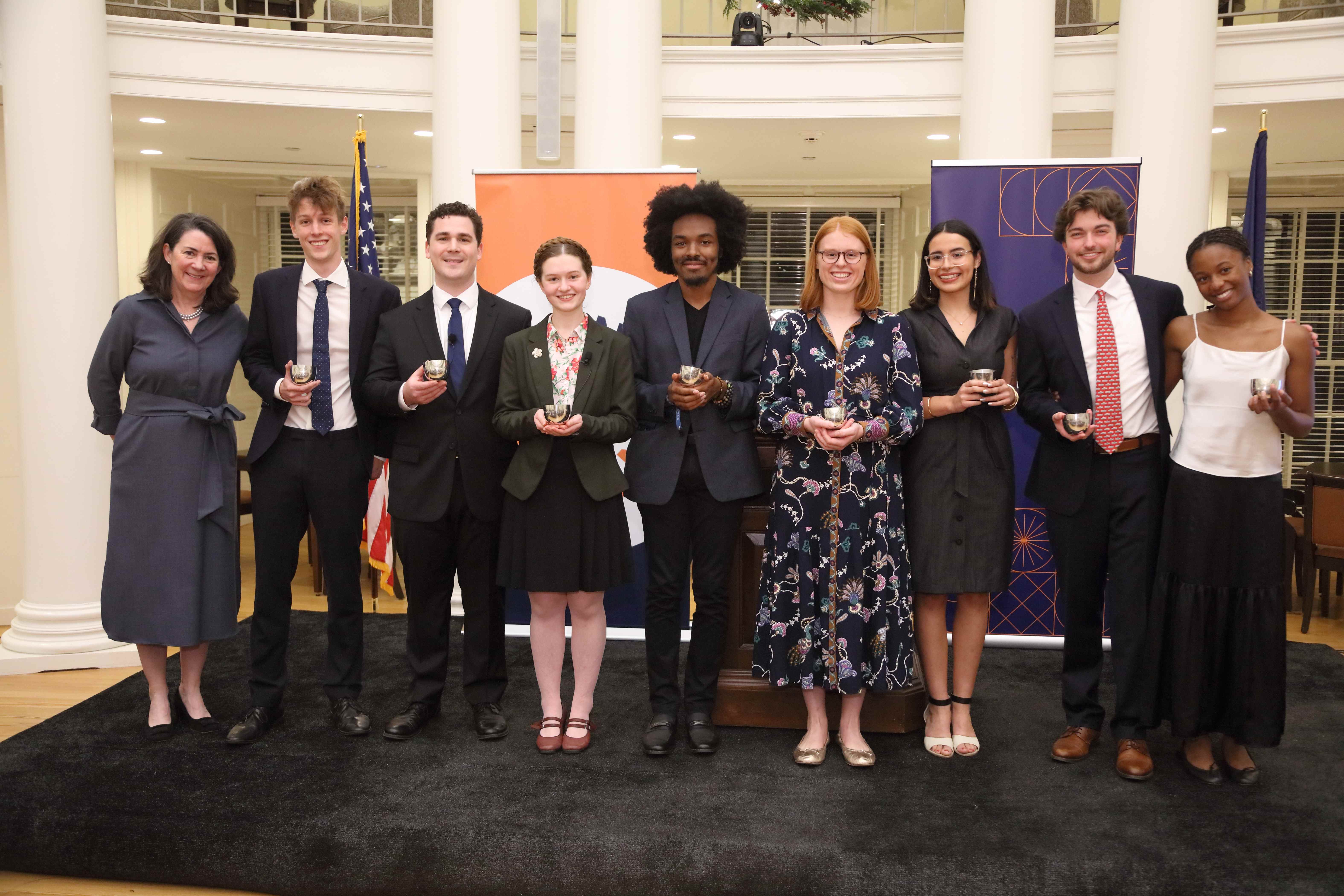 Students and faculty celebrating achievements with awards in university setting