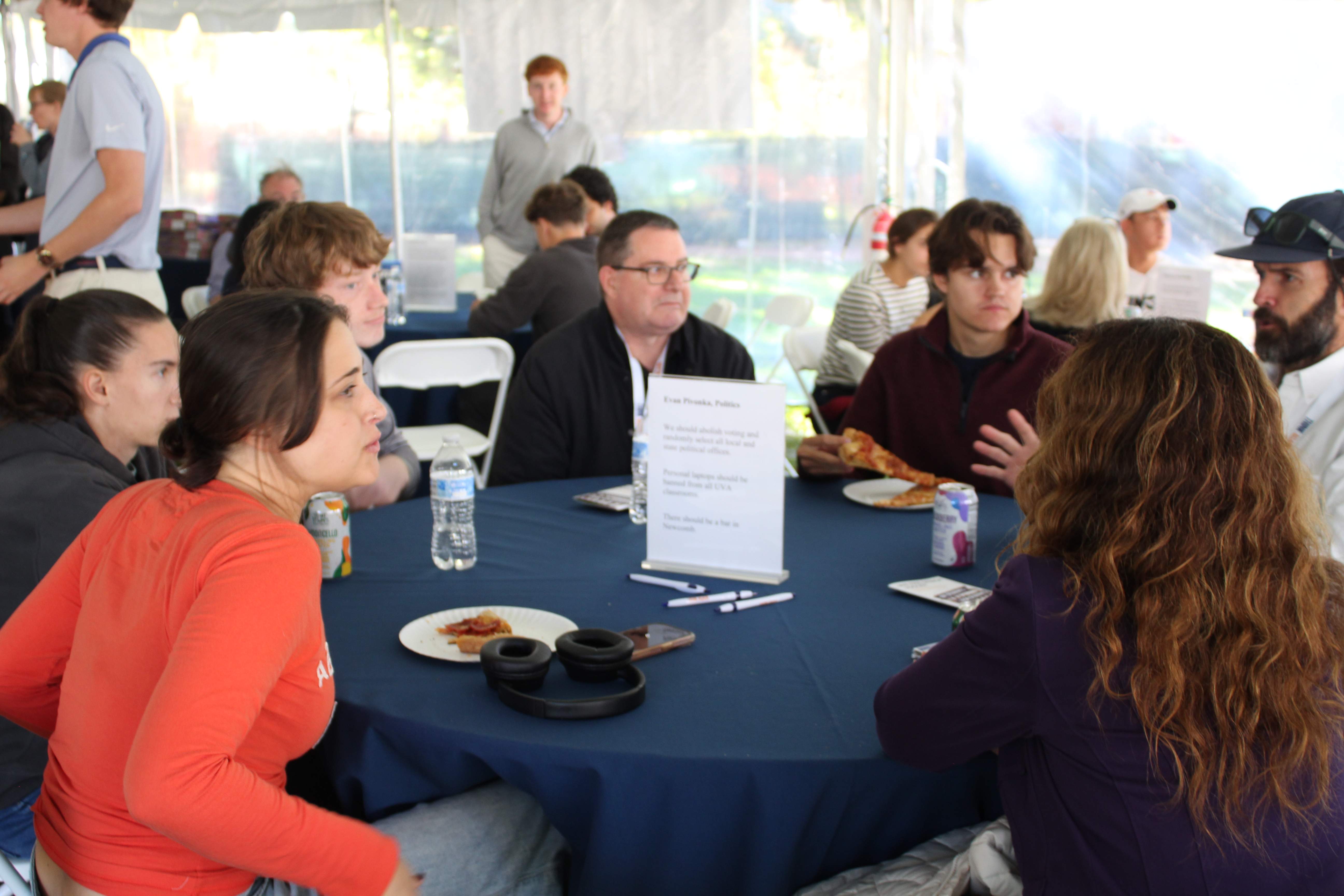 Outdoor tent event with table discussions